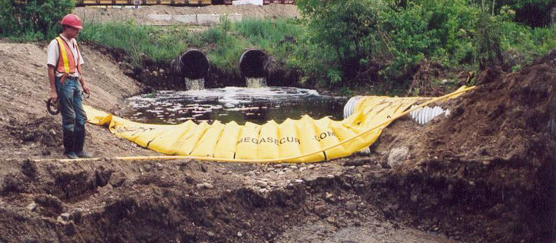 Flexibele Water-Gate © -kisterdam die dient als opvangbassin met afvoer van de overloop door middel van een leiding.